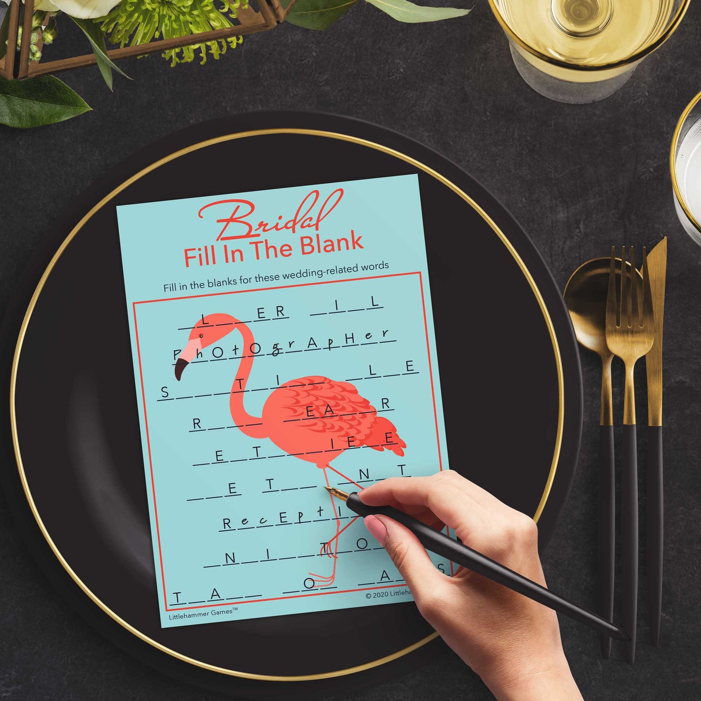 Woman with a pen playing a flamingo Bridal Fill in the Blank game card at a dark place setting