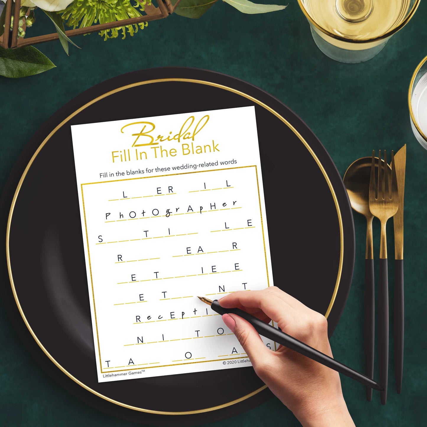 Woman with a pen playing a gold and white Bridal Fill in the Blank game card at a dark place setting