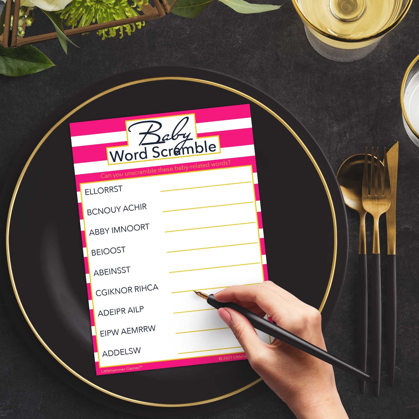 Woman playing a pink-striped Baby Word Scramble game card at a green and black place setting