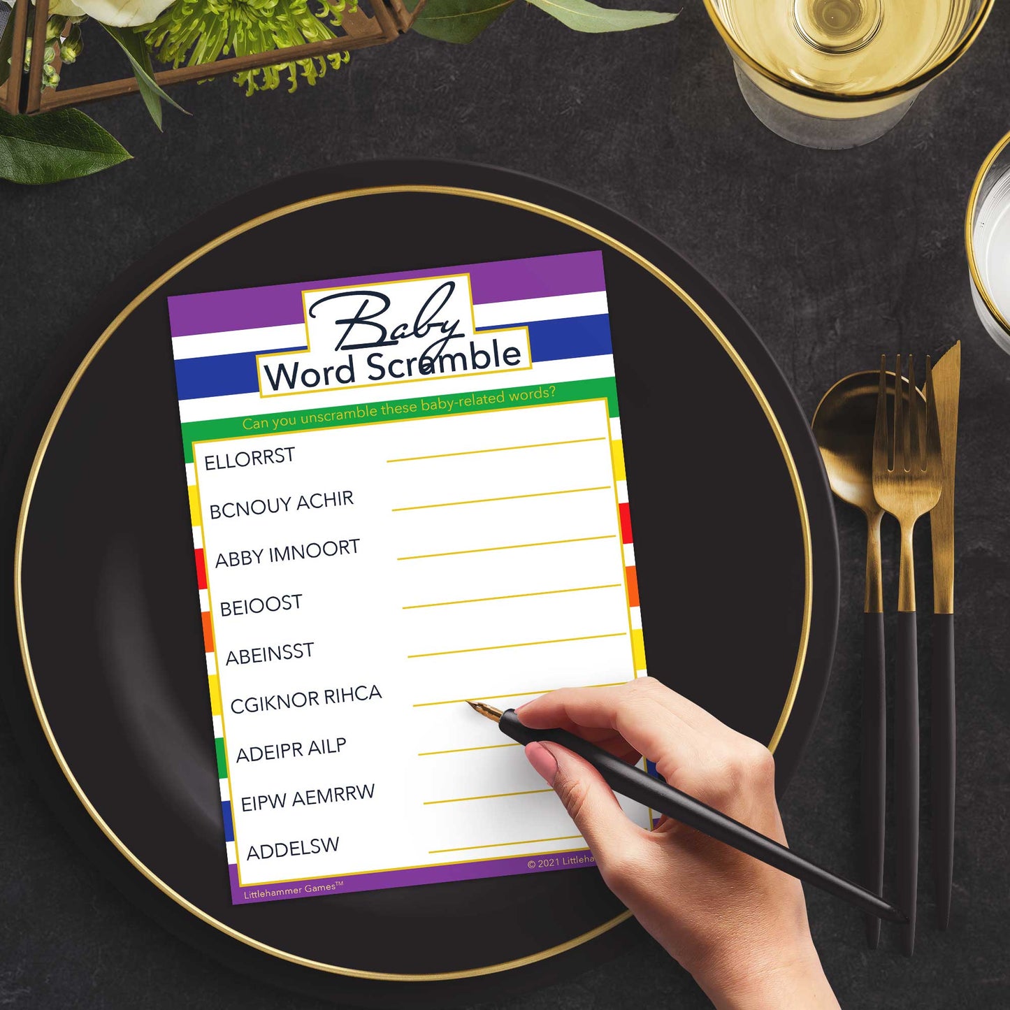 Woman playing a rainbow-striped Baby Word Scramble game card at a green and black place setting