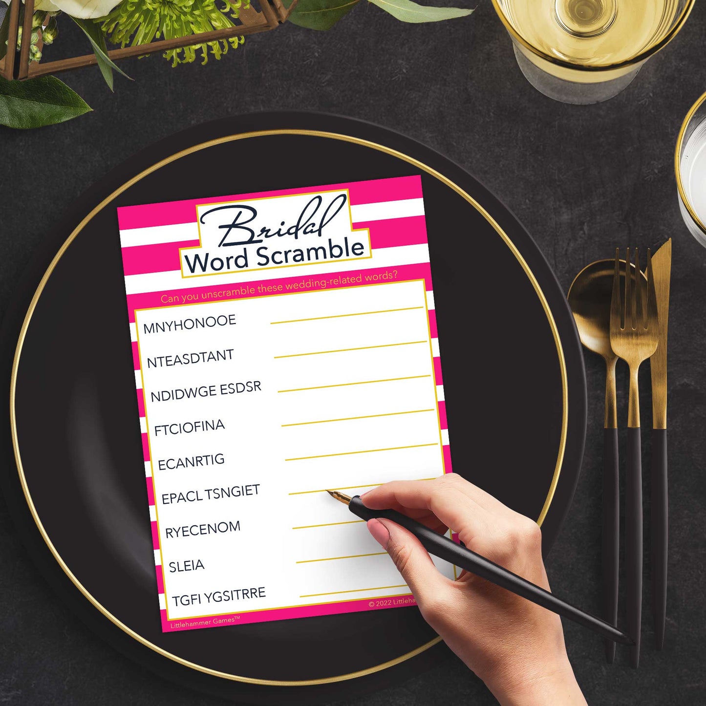 Woman with a pen playing a pink-striped Bridal Word Scramble game card at a dark place setting