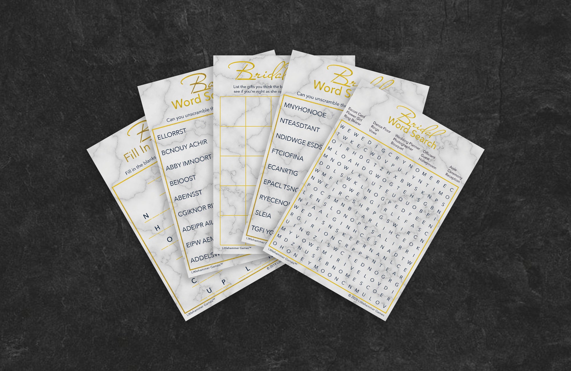 Gold and marble game cards fanned out on a slate background