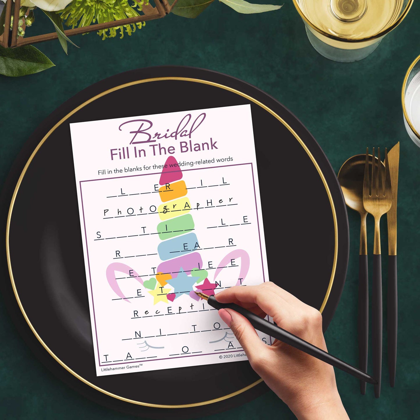 Woman with a pen playing a unicorn-themed Bridal Fill in the Blank game card at a dark place setting
