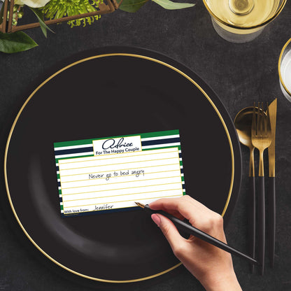 Woman with a pen sitting at a dark place setting with a black and gold plate filling out a green and navy-striped Advice for the Happy Couple card
