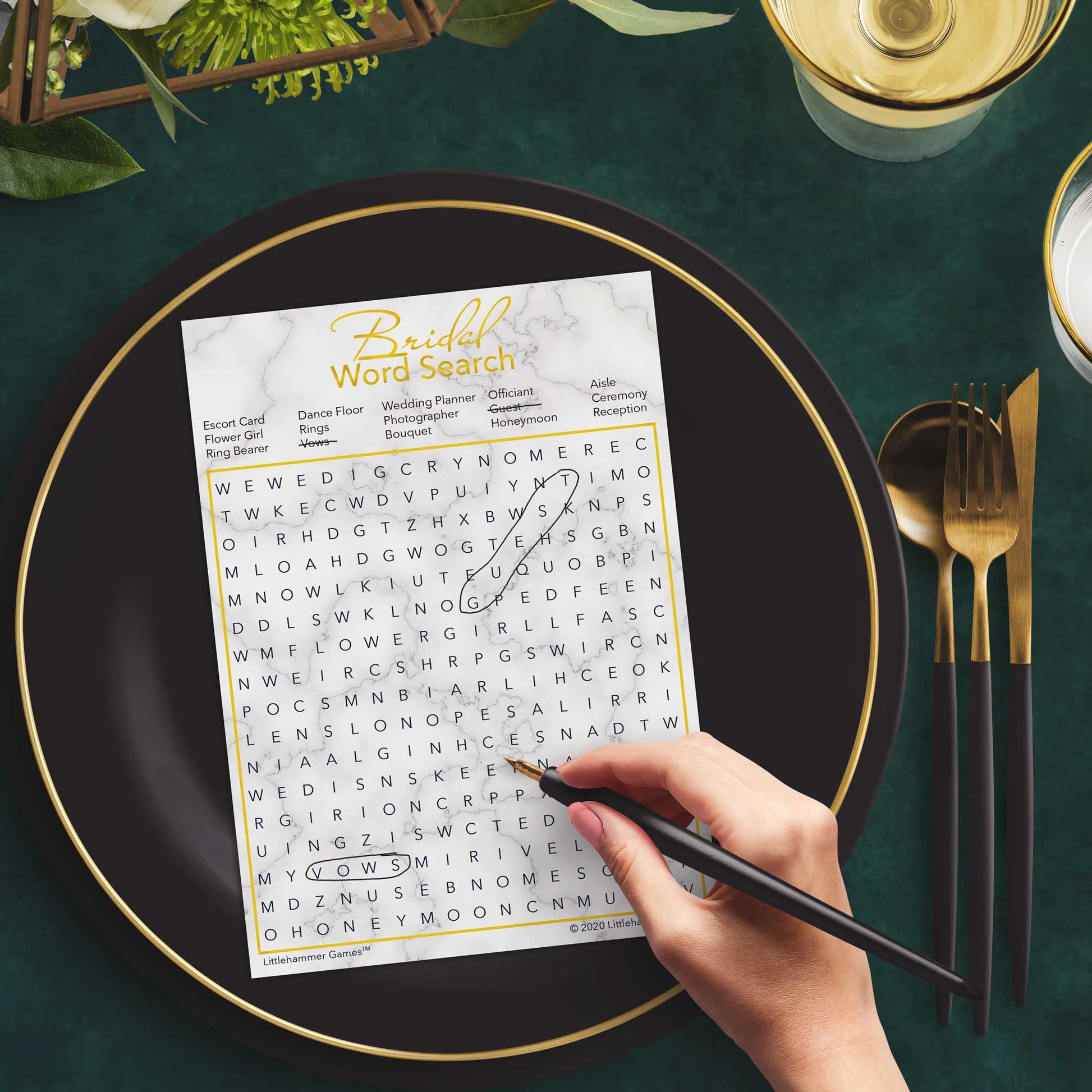 Woman with a pen playing a gold and marble Bridal Word Search game card at a dark place setting