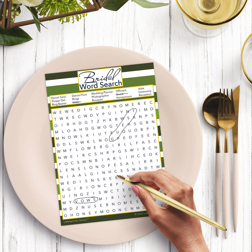 Woman with a pen playing a green-striped Bridal Word Search game card at a dark place setting