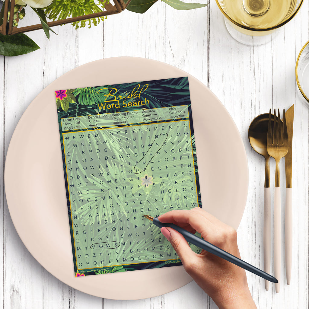 Woman with a pen playing a tropical Bridal Word Search game card at a dark place setting
