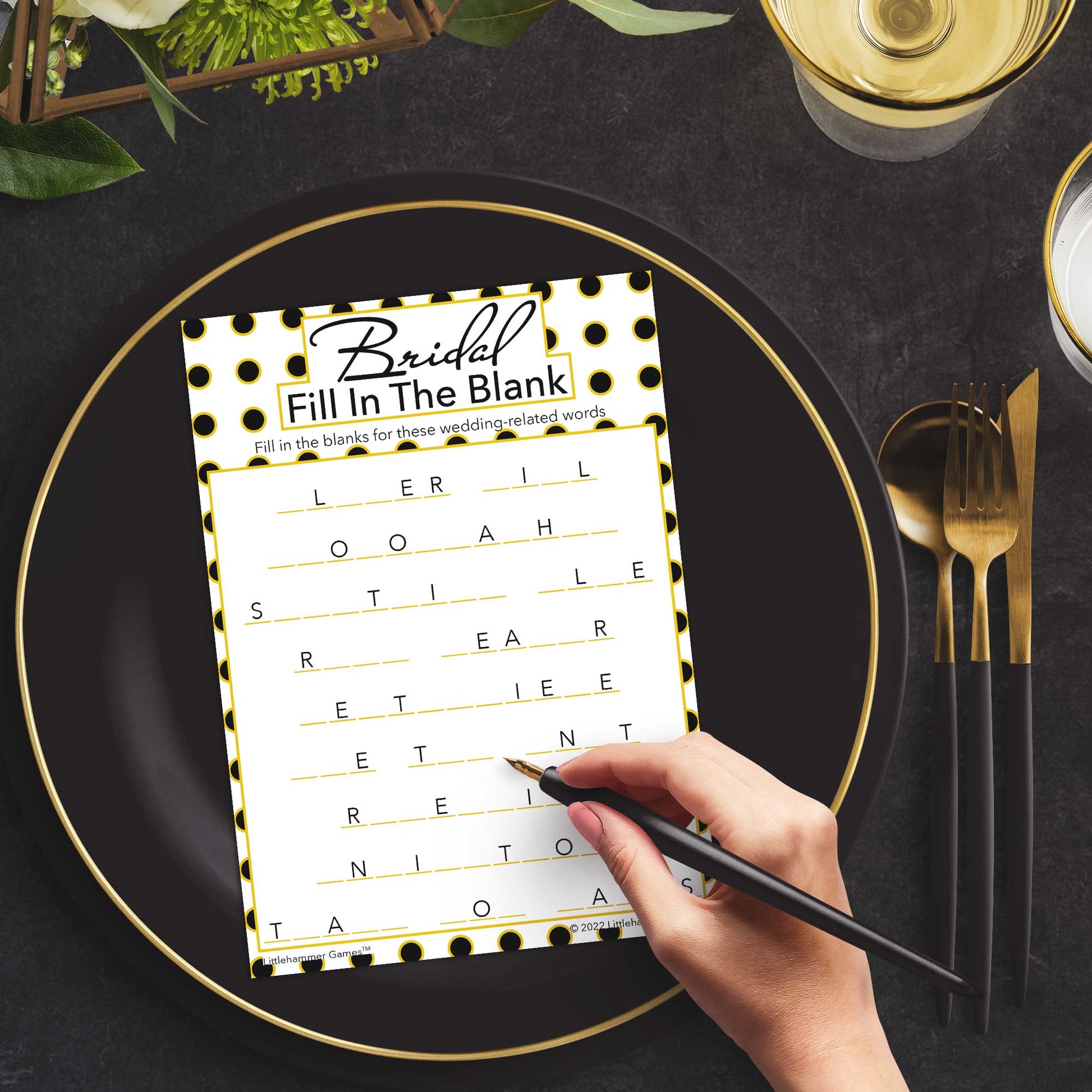 Woman with a pen playing a black and gold polka dot Bridal Fill in the Blank game card at a dark place setting